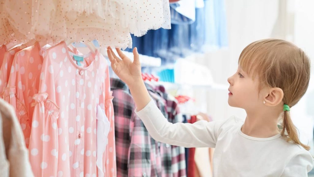 petite fille regarde vetement boutique